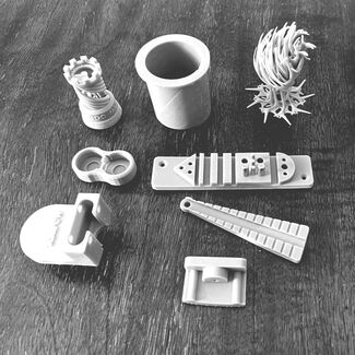 A black and white photo of eight 3D printed objects
